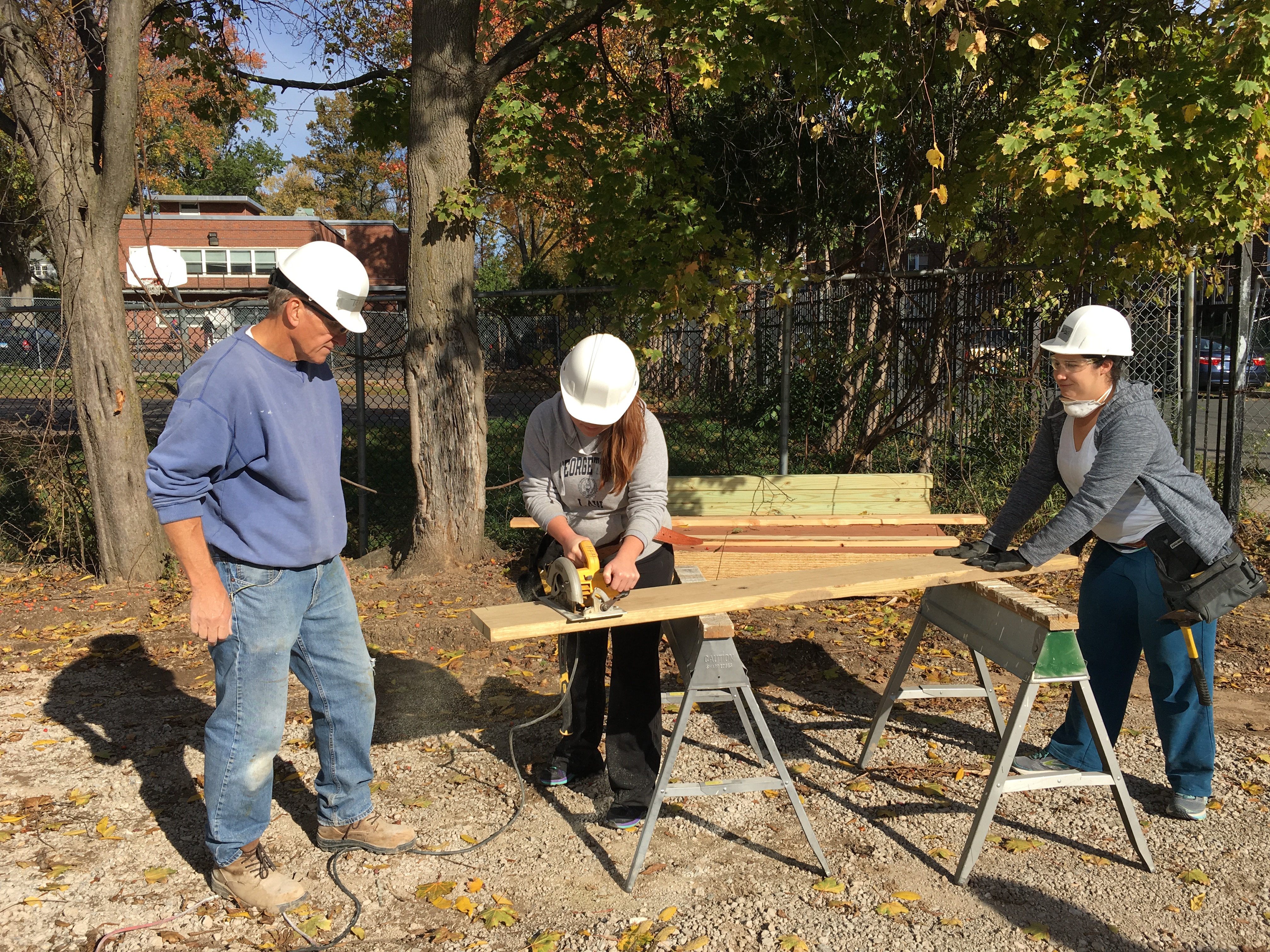 Habitat volunteer, YLS Tax Law Committee Chair Lauren M. McNair, and YLS Chair Aidan R. Welsh cut wood for the deck.